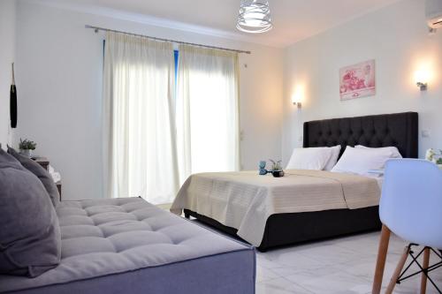 a bedroom with a large bed and a couch at The Blue Rooms in Áyioi Apóstoloi