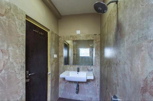 a bathroom with a sink and a mirror at Wonderful View Hotel WR Bhavnagar in Bhavnagar