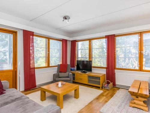 ein Wohnzimmer mit Sofa und Fernseher in der Unterkunft Holiday Home Karhunvartijan pirtti b2 by Interhome in Ruka