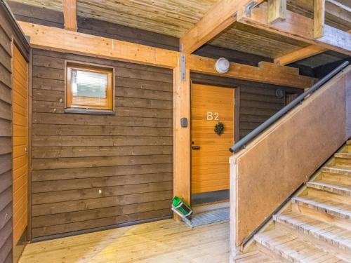 ein Zimmer mit einer Treppe in einer Hütte mit Holzwänden in der Unterkunft Holiday Home Karhunvartijan pirtti b2 by Interhome in Ruka