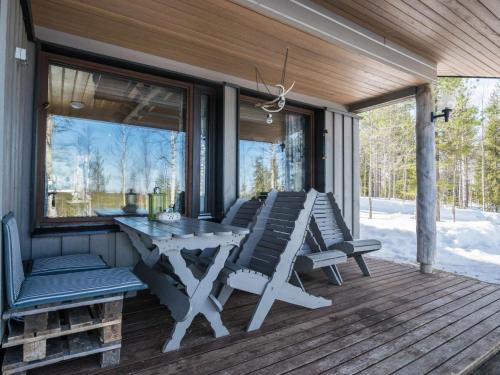 a screened porch with a table and chairs on it at Holiday Home Mustalampi 5 satakieli by Interhome in Ruka
