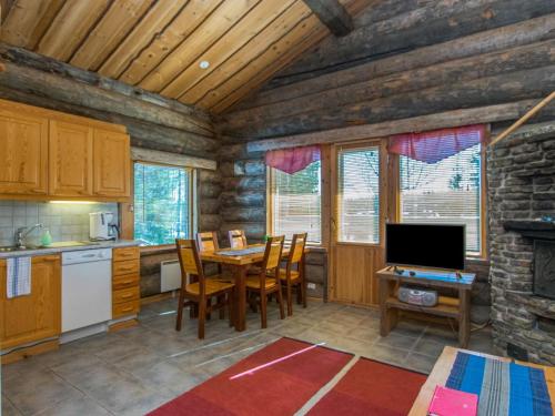 eine Küche und ein Esszimmer mit einem Tisch und einem TV in der Unterkunft Holiday Home Rinnekieppi 1 by Interhome in Ruka