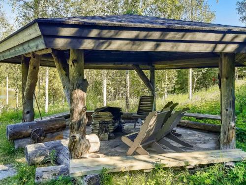 einen hölzernen Pavillon mit 2 Stühlen und einem Tisch in der Unterkunft Holiday Home Mustalampi 2 kurkiaura by Interhome in Ruka