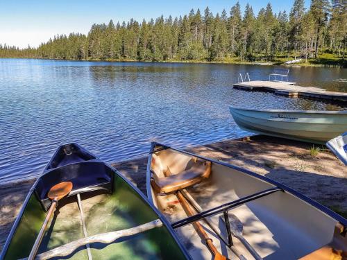 zwei Boote, die auf einem Dock auf einem See sitzen in der Unterkunft Holiday Home Mustalampi 2 kurkiaura by Interhome in Ruka