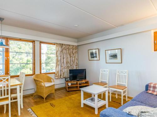 a living room with a couch and a tv at Holiday Home Karhunvartijan linna c18 by Interhome in Ruka
