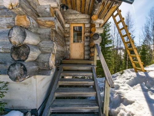 ein Blockhaus im Schnee mit einer Holztür in der Unterkunft Holiday Home Rinnekieppi 2 by Interhome in Ruka