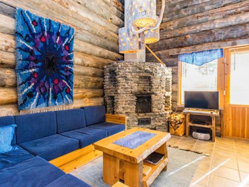 sala de estar con sofá azul y chimenea en Holiday Home Rinnekieppi 2 by Interhome, en Ruka