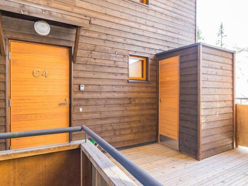 two doors on the side of a wooden building at Holiday Home Karhunvartijan pirtti c4 by Interhome in Ruka