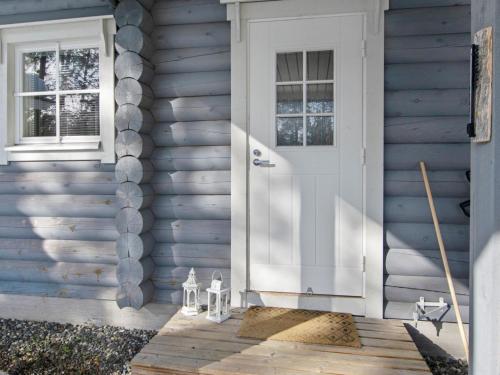 a blue house with a white door on a porch at Holiday Home Sini-ruka 1 by Interhome in Ruka