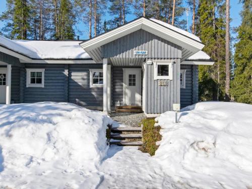 a blue house with snow in front of it at Holiday Home Sini-ruka 1 by Interhome in Ruka