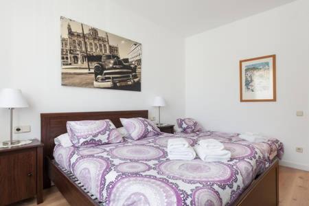1 cama en una habitación con una foto en la pared en Piso Zona Plaza España, junto a Montjuic, en Barcelona