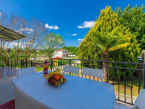 a white table with a bowl of fruit on it at Holiday Home Dora by Interhome in Modrušani
