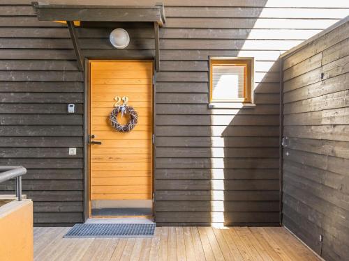 a wooden door with a wreath on a house at Holiday Home Karhunvartijan linna c22 by Interhome in Ruka
