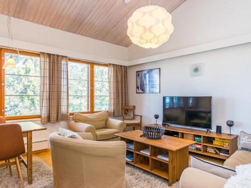 a living room with a couch and a tv at Holiday Home Karhunvartijan linna c22 by Interhome in Ruka