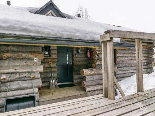 a wooden cabin with snow on the roof and a door at Holiday Home Saaruanaho h1 by Interhome in Ruka