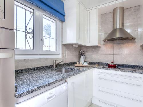 a kitchen with white cabinets and a sink and a window at Holiday Home Afrodita by Interhome in L'Escala