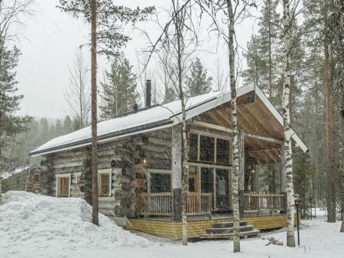 eine Blockhütte im Wald im Schnee in der Unterkunft Holiday Home Kotkanpesä by Interhome in Levi