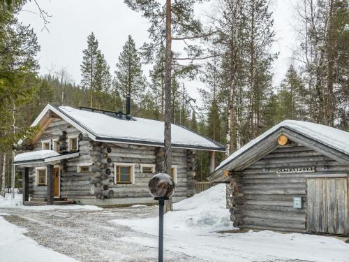 レヴィにあるHoliday Home Kotkanpesä by Interhomeの雪中のログキャビン(駐車場メーター付)