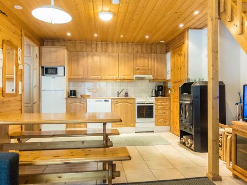 eine Küche mit Holzschränken und einem Holztisch in der Unterkunft Holiday Home Hirvas levi 4 by Interhome in Levi