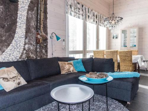 a living room with a blue couch and two tables at Holiday Home Rapsakka by Interhome in Levi