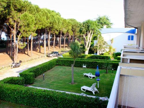 Silvi PaeseにあるApartment Cerrano by Interhomeの椅子と青い傘が備わる庭園の景色を望めます。
