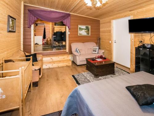 a bedroom with a bed and a living room at Holiday Home Mäntymäki by Interhome in Kelkala