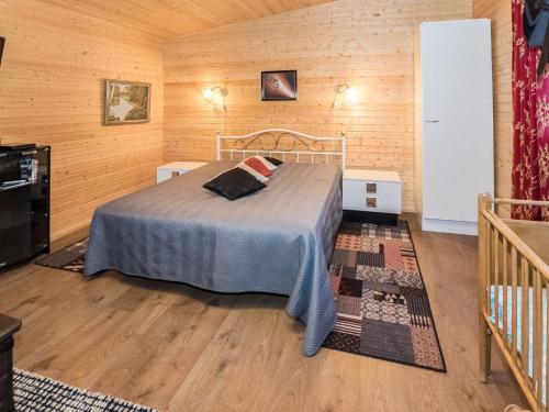 a bedroom with a bed in a room with wooden walls at Holiday Home Mäntymäki by Interhome in Kelkala