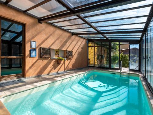 an indoor swimming pool with a glass ceiling and a house at Holiday Home I Briganti by Interhome in Narzole