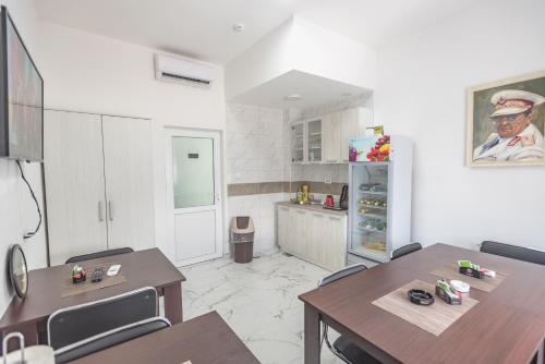 Vila Safir في لوزنيكا: مطبخ مع طاولة وكراسي وثلاجة