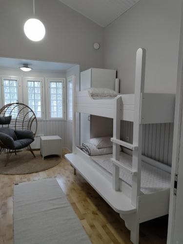 a bedroom with two bunk beds and a chair at Nuorisokeskus Villa Elba in Kokkola