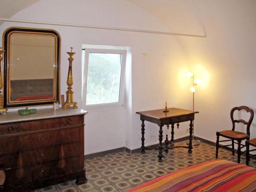 a bedroom with a dresser and a mirror and a table at Holiday Home Miche by Interhome in Collabassa