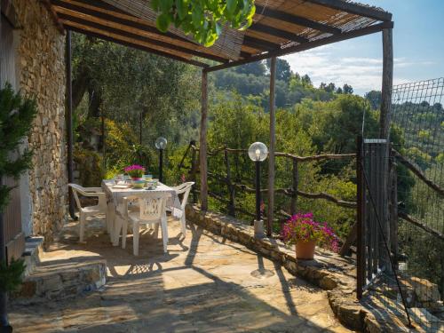 a table and chairs on a patio with a view at Holiday Home Casa U Baregu by Interhome in Diano San Pietro