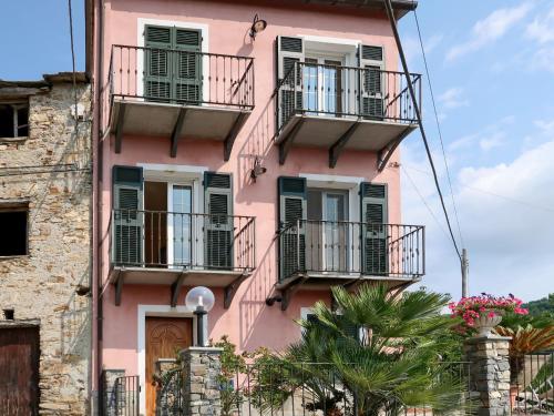un edificio rosa con balcones y palmeras en Holiday Home Casa Marco by Interhome, en Caravonica