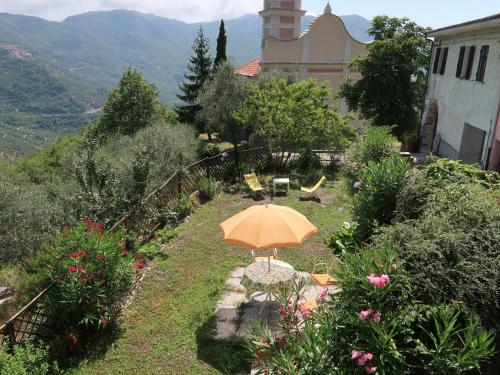 un giardino con un ombrellone arancione nell'erba di Holiday Home Casa Barba by Interhome a Caravonica