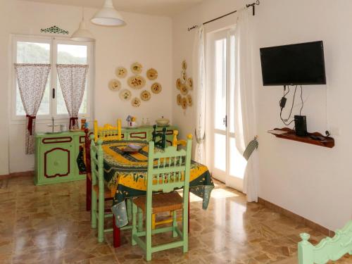 Holiday Home Casa Barba by Interhome في Caravonica: غرفة طعام مع طاولة وتلفزيون