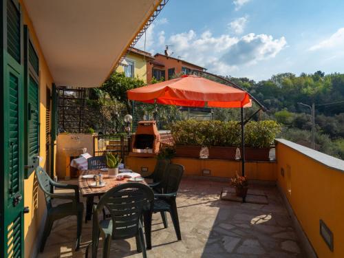 a patio with a table and chairs and an umbrella at Apartment A' Ca' de Alida by Interhome in Ortovero