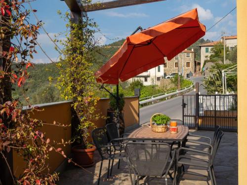 a table and chairs with an umbrella on a balcony at Apartment A' Ca' de Alida by Interhome in Ortovero