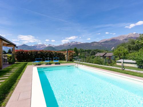uma piscina com montanhas ao fundo em Holiday Home Gelsomini - CCO522 by Interhome em Colico