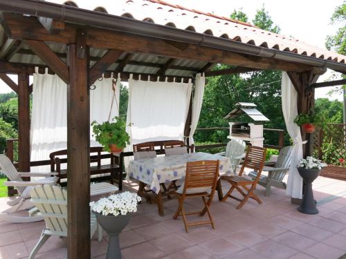un pabellón de madera con una mesa y sillas en un patio en Holiday Home Il Cavaliere by Interhome, en Castellero