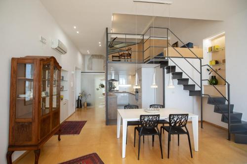 uma sala de jantar com uma mesa e uma escada em Seaview Design Homes in Ortigia by Wonderful Italy em Siracusa