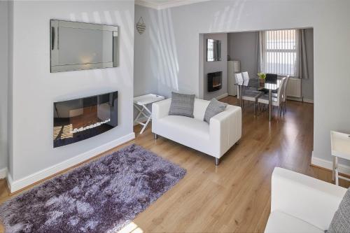ein Wohnzimmer mit einer weißen Couch und einem Kamin in der Unterkunft Host & Stay - 1 Oswy Street in Whitby