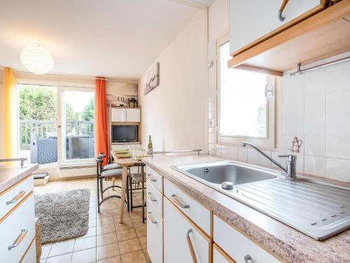 a kitchen with a sink and a large window at Apartment Les Christophines-3 by Interhome in Cabourg