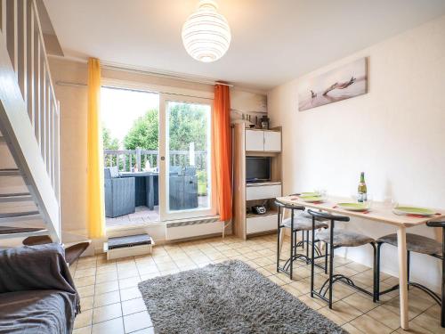 a living room with a table and a dining room at Apartment Les Christophines-3 by Interhome in Cabourg