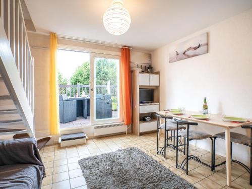 a living room with a table and a dining room at Apartment Les Christophines by Interhome in Cabourg