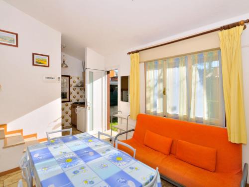 un soggiorno con divano arancione e letto di Holiday Home Cassiopea-1 by Interhome a Bibione
