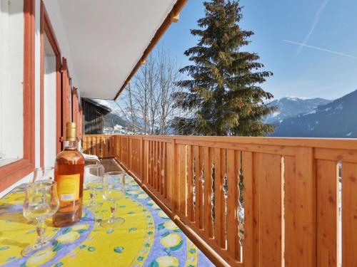 a table with wine glasses and a bottle on a balcony at Apartment Tieja de Gotart-1 by Interhome in Vigo di Fassa