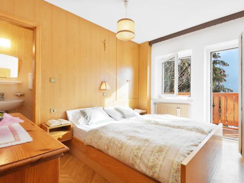 a bedroom with a large bed and a sink at Apartment Tieja de Gotart-1 by Interhome in Vigo di Fassa