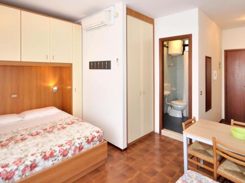um quarto com uma cama, uma mesa e uma casa de banho em Apartment Cavallino by Interhome em Bibione