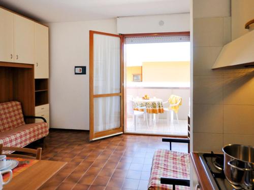 uma sala de estar com uma cozinha e uma mesa em Apartment Cavallino by Interhome em Bibione