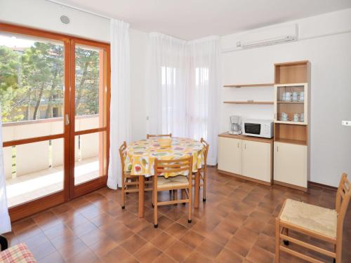cocina y comedor con mesa y sillas en Apartment Cavallino - BIB116 by Interhome en Bibione
